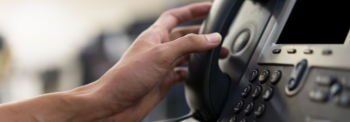 Hand, die zu Telefonhörer greift