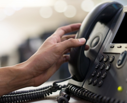 Hand, die zu Telefonhörer greift